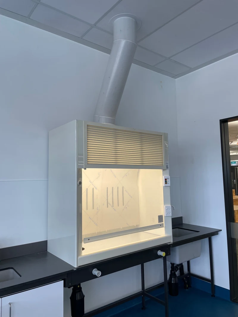 Installed laboratory fume cupboard with a glazed working opening